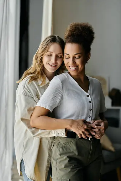 A diverse lesbian couple shares a tender moment together at home. — Stock Photo