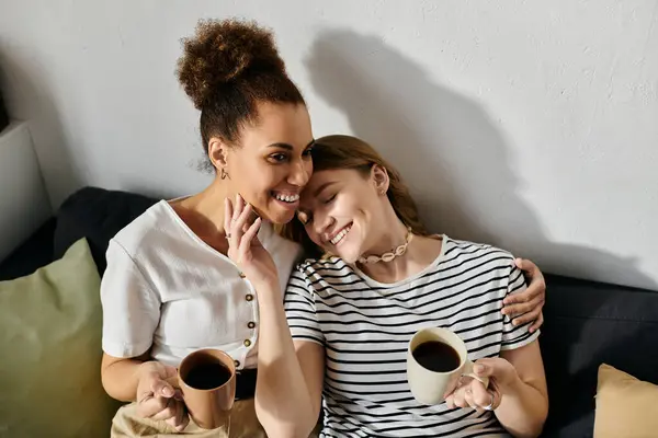 Una coppia lesbica si gode una tazza di caffè e ogni altri compagnia a casa. — Foto stock