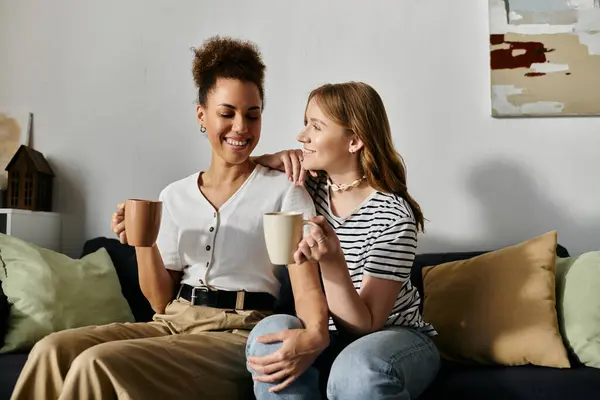 Two women, a lesbian couple, relax and enjoy each others company in a cozy home setting. — Stock Photo