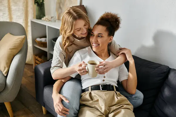 A lesbian couple relaxes at home, enjoying coffee and each others company. — Stock Photo