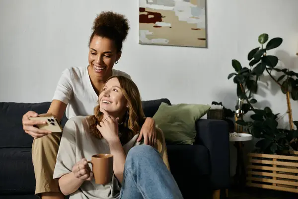 A lesbian couple takes a selfie while relaxing on a couch at home. — Stock Photo