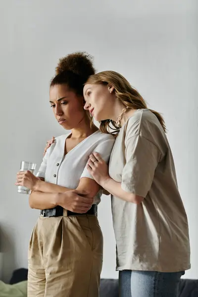 A diverse lesbian couple embraces in their home, finding comfort in each others presence. — Stock Photo