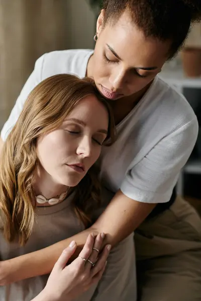 A diverse lesbian couple embraces in their home, finding solace and love in each others presence. — Stock Photo