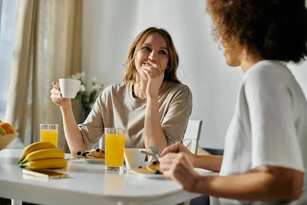 A lesbian couple enjoys a morning coffee together at home. — Stock Photo