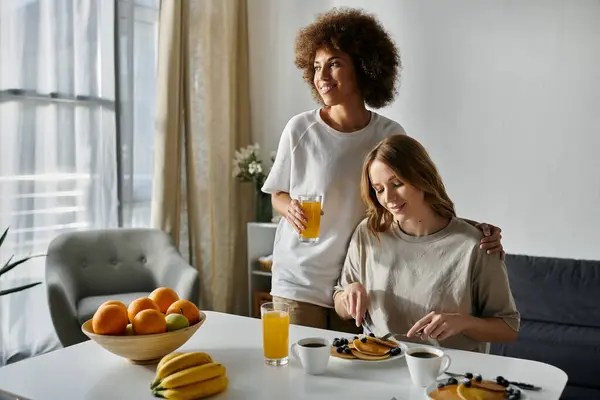 Two women share a meal together at home. — Stock Photo