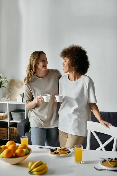 A lesbian couple enjoys a morning together at home, sharing coffee and conversation. — Stock Photo