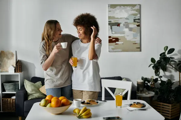 A happy lesbian couple enjoys coffee and conversation at home. — Stock Photo