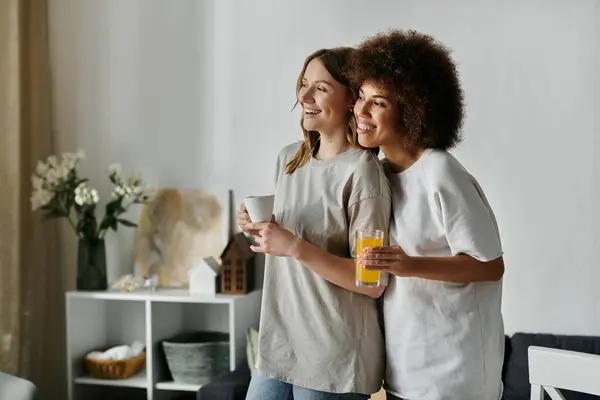 A lesbian couple relaxes at home, enjoying drinks together. — Stock Photo