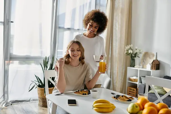 A diverse lesbian couple enjoys breakfast together at home. — Stock Photo