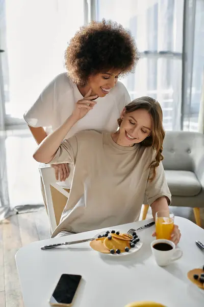 A lesbian couple enjoys breakfast together at home. — Stock Photo