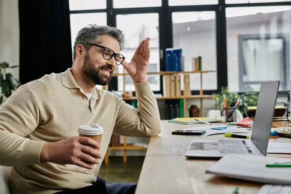 Un bel homme d'affaires avec une barbe travaille à son bureau dans un bureau moderne. — Photo de stock