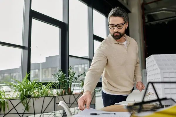 Un hombre de negocios con barba está trabajando en un proyecto en su escritorio en una oficina moderna. — Stock Photo