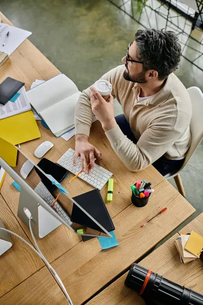 Un bel homme d'affaires avec une barbe travaille sur son ordinateur à un bureau moderne. — Photo de stock