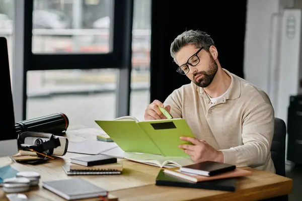 Ein gutaussehender Geschäftsmann mit Bart konzentriert sich auf seine Arbeit in einem modernen Büro. Er überprüft Dokumente und verwendet einen Textmarker. — Stockfoto