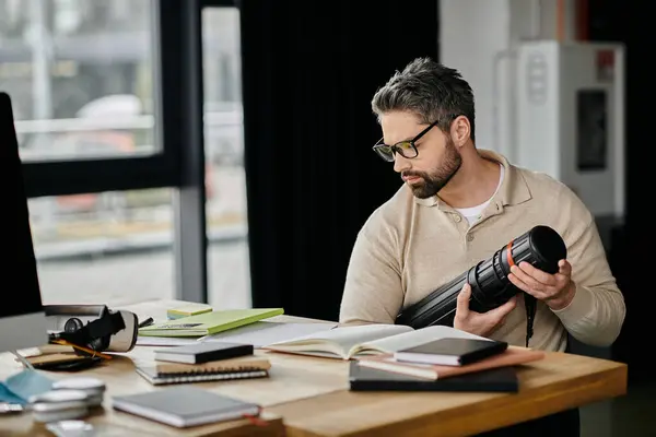 A handsome businessman with a beard works in a modern office, holding a black tube. — Stock Photo