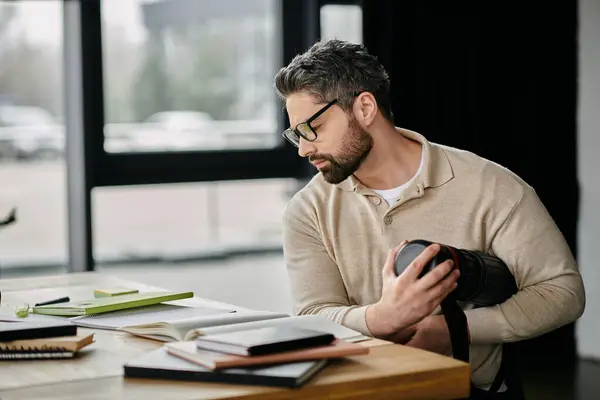 A handsome businessman with a beard works at a desk in a modern office. — Stock Photo