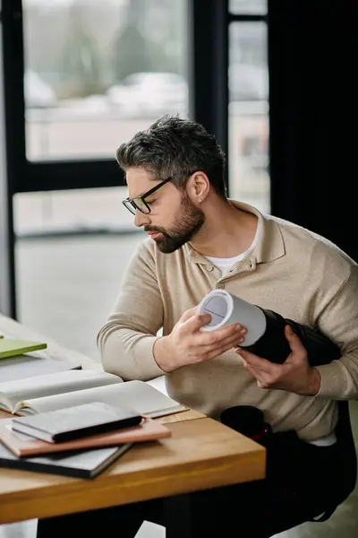 Ein gutaussehender Geschäftsmann mit Bart sitzt an einem Schreibtisch in einem modernen Büro — Stockfoto