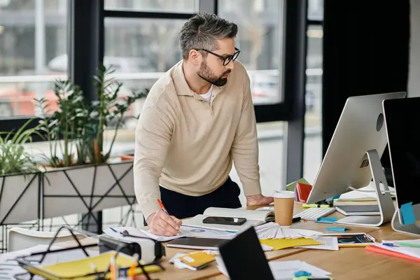 Ein Geschäftsmann mit Bart arbeitet an seinem Schreibtisch in einem modernen Büro. — Stockfoto