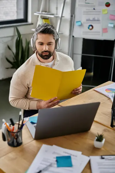 A handsome businessman with a beard sits at his desk, reviewing documents in a modern office. — Stock Photo