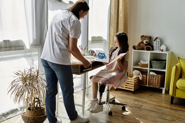 A brunette mother and her daughter with a prosthetic leg are spending quality time at home, engaging in creative activities together. — Stock Photo
