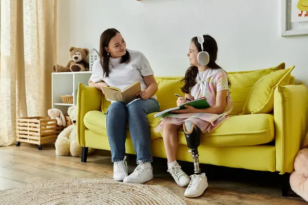 A mother and her daughter with a prosthetic leg are spending quality time together at home. — Stock Photo
