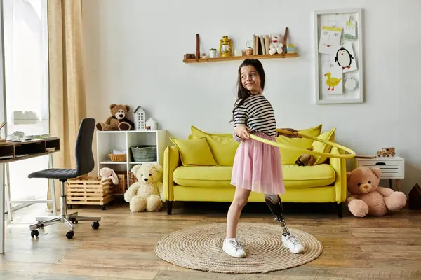 Ein junges Mädchen mit Beinprothese dreht freudig einen Hula-Hoop-Reifen in ihrem Wohnzimmer, umgeben von Spielzeug — Stockfoto