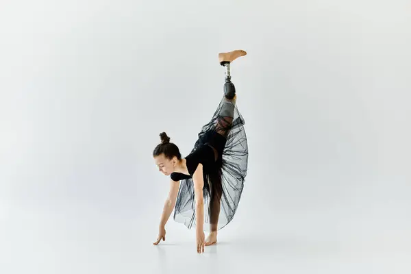 Uma jovem com uma perna protética executa uma pose de ginástica graciosa. — Fotografia de Stock