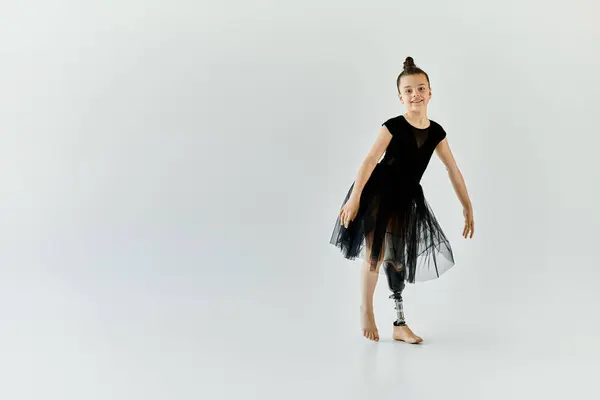 A young girl with a prosthetic leg performs a graceful gymnastics pose. — Stock Photo