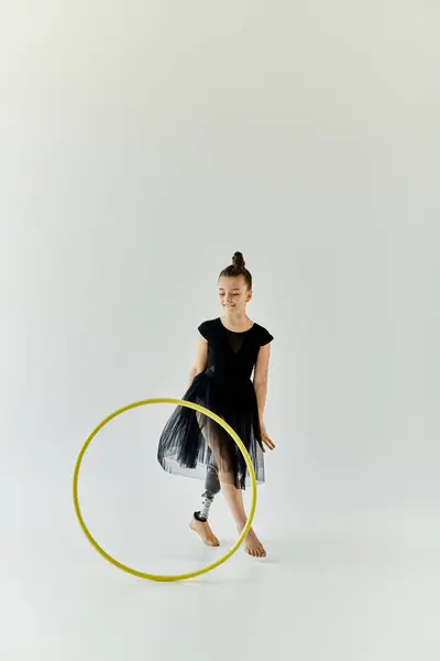 A young girl with a prosthetic leg performs gymnastics with a hula hoop. — Stock Photo