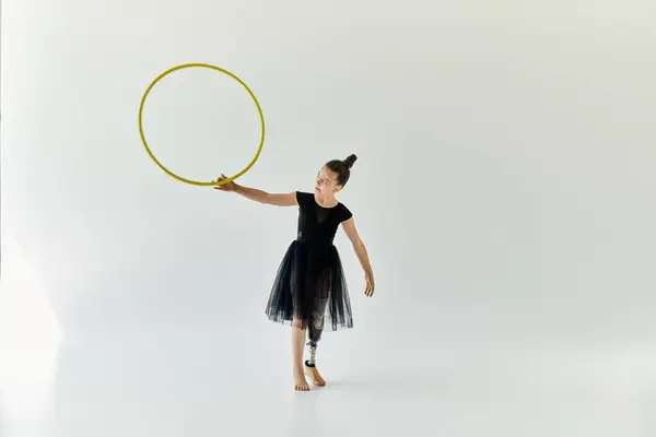 Una giovane ragazza con una gamba protesica pratica ginnastica con un cerchio. — Foto stock