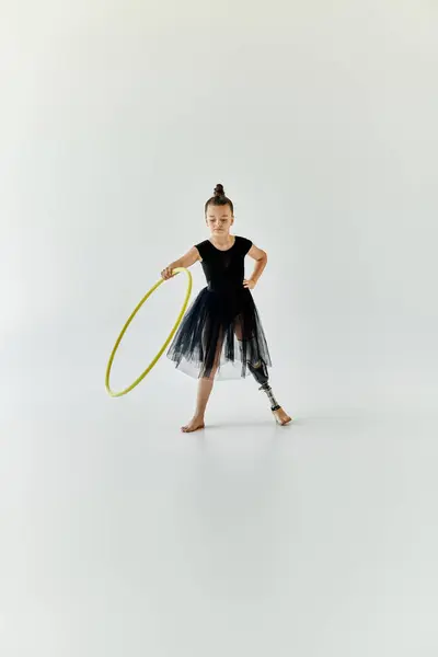A young girl with a prosthetic leg practices gymnastics with a hoop. — Stock Photo