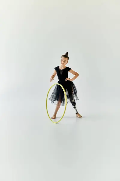 A young girl with a prosthetic leg practices gymnastics with a hoop. — Stock Photo