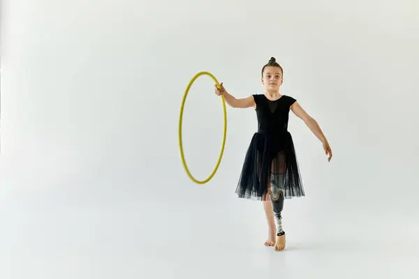 A young girl with a prosthetic leg performs a gymnastics routine with a hula hoop. — Stock Photo