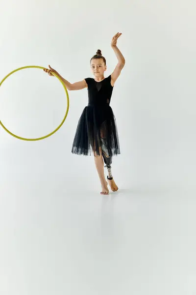 A young girl with a prosthetic leg performs gymnastics with a hoop. — Stock Photo