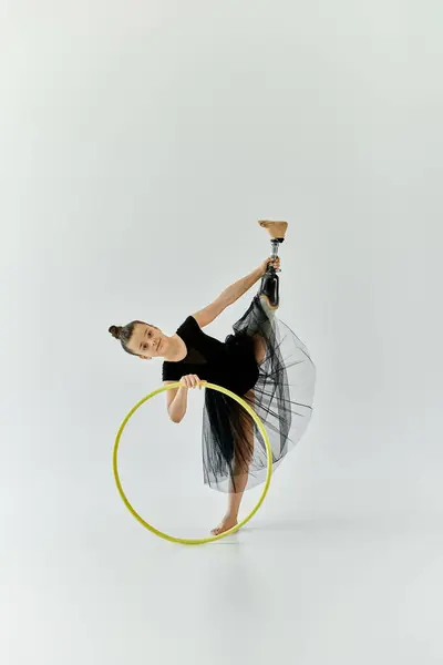 A young girl with a prosthetic leg performs a gymnastic routine with a hoop. — Stock Photo