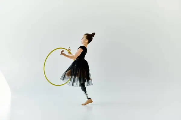 A young girl with a prosthetic leg performs a graceful gymnastic routine with a hoop. — Stock Photo