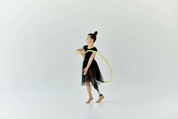 A young girl with a prosthetic leg performs a gymnastics routine with a hoop. — Stock Photo