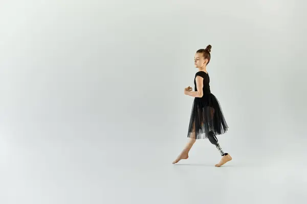Молодая девушка с протезной ногой совершает грациозный прыжок во время занятий гимнастикой. — стоковое фото