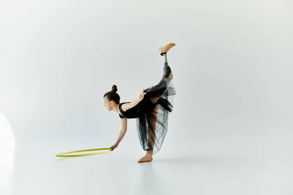 A young girl with a prosthetic leg performs a gymnastic routine with a hoop. — Stock Photo