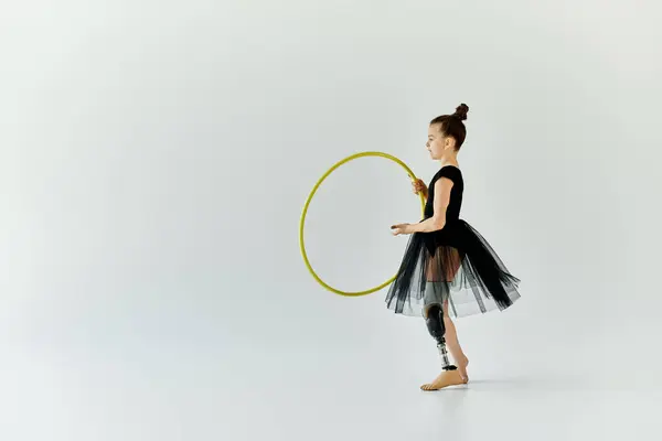 A young girl with a prosthetic leg practices gymnastics with a hoop. — Stock Photo