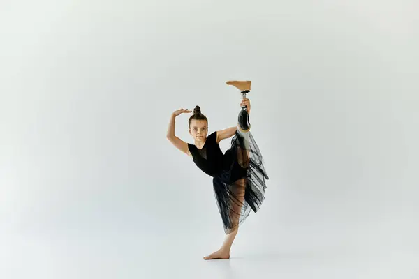 A young girl with a prosthetic leg performs a gymnastics move with grace and strength. — Stock Photo