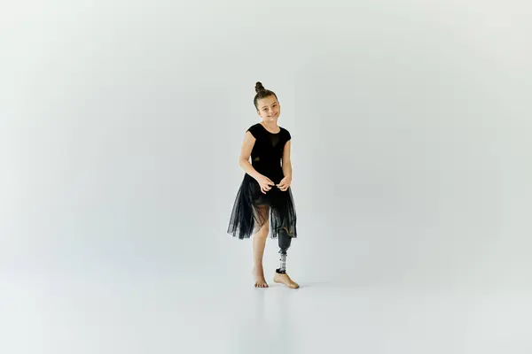 A young girl with a prosthetic leg stands confidently in a gymnastic pose. — Stock Photo