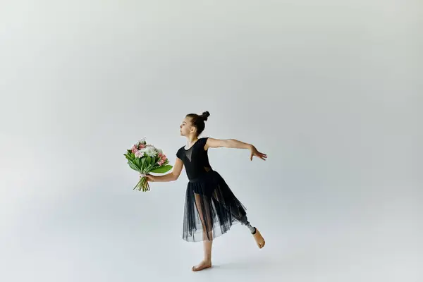 A young gymnast with a prosthetic leg performs a graceful pose while holding a bouquet of flowers. — Stock Photo