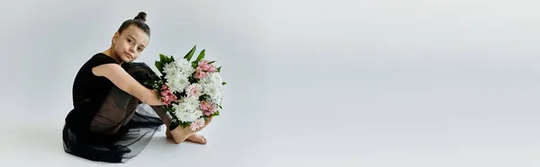 A young girl with a prosthetic leg sits gracefully, holding a bouquet of flowers. — Stock Photo