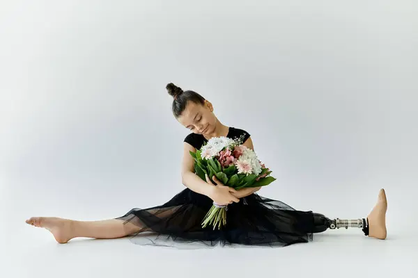Ein junges Mädchen mit Beinprothese vollführt anmutig einen Spagat, während sie einen Blumenstrauß in der Hand hält. — Stockfoto