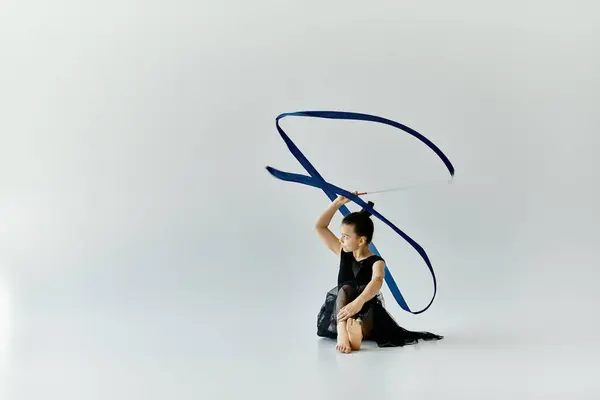A young girl with a prosthetic leg performs a graceful ribbon routine in a gymnastics studio. — Stock Photo