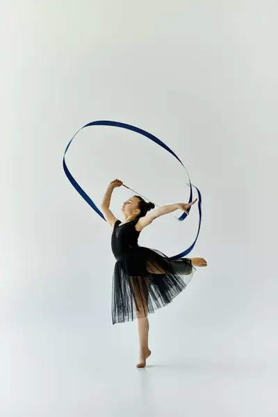 Una joven con una pierna protésica realiza con gracia una rutina de gimnasia con una cinta. — Stock Photo