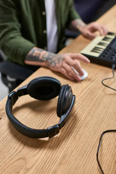 A pair of black headphones lay on a wooden table in a recording studio. — Stock Photo