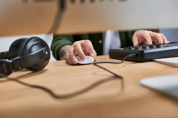A close-up of a handsome Asian man using a midi controller in a studio. — Stock Photo