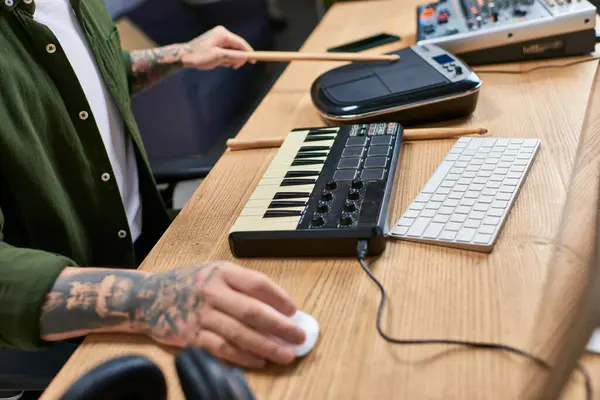 A tattooed Asian man plays instruments in a recording studio. — Stock Photo